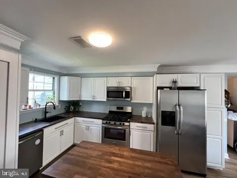 a kitchen with granite countertop white cabinets and white appliances