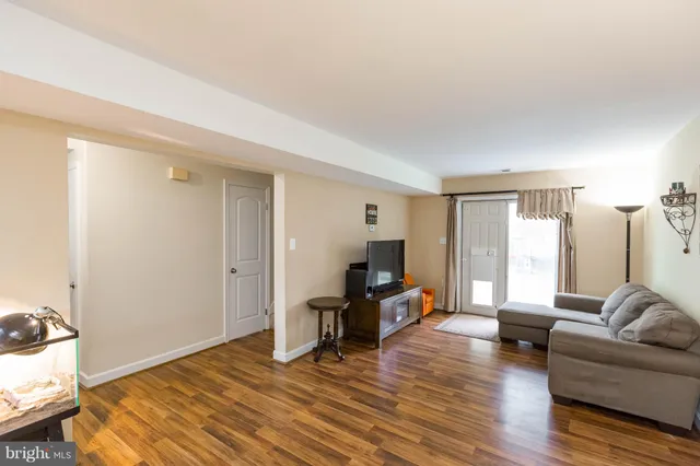 a kitchen with a refrigerator a stove a sink dishwasher and a dining table with wooden floor