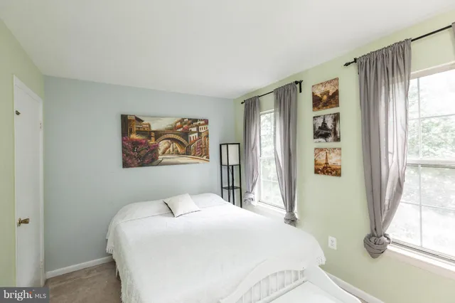 a bedroom with a bed and a large window