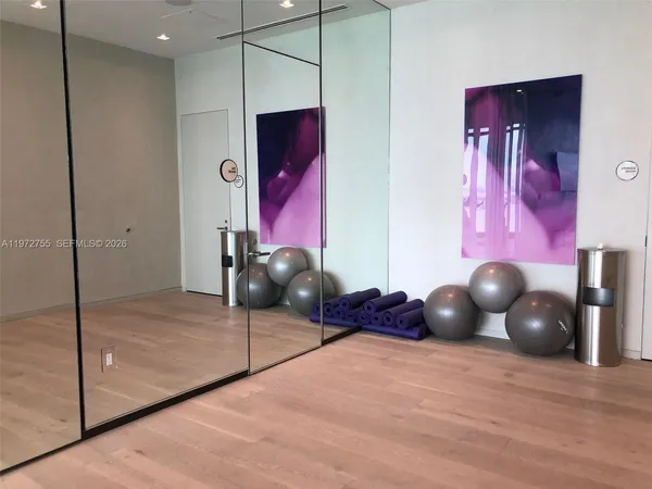 a room with gym equipment and large mirror