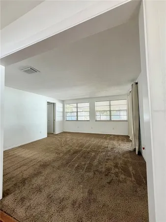 an empty room with windows and cabinet