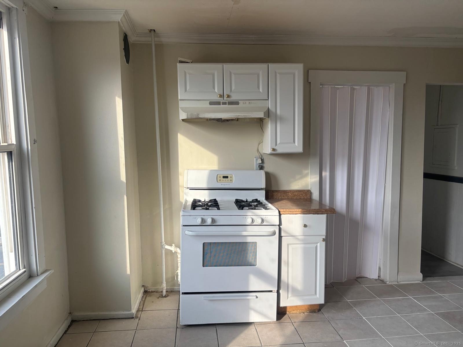 a kitchen with a stove top oven and cabinets