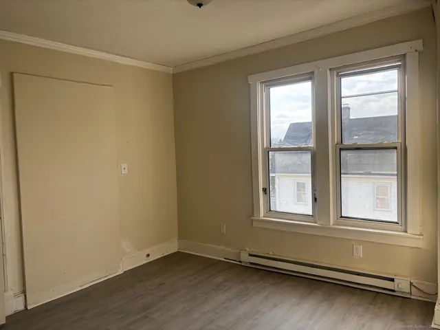 a view of a room with wooden floor and windows