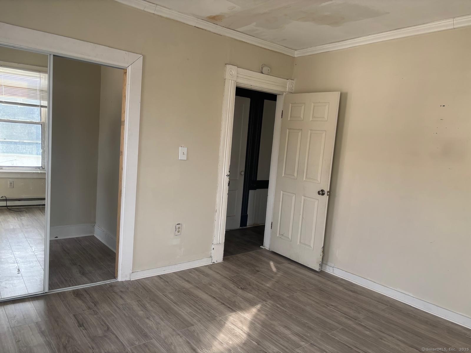 1308 East Main Street Waterbury, CT 06705 - Photo 5 of 10 an empty room with wooden floor and windows