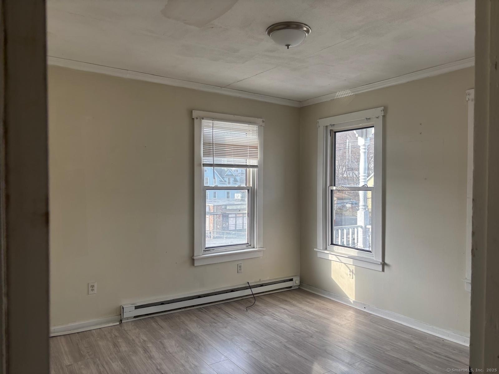 1308 East Main Street Waterbury, CT 06705 - Photo 9 of 10 an empty room with wooden floor and windows
