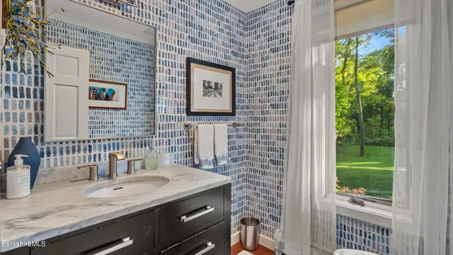 a bathroom with a granite countertop sink and a mirror
