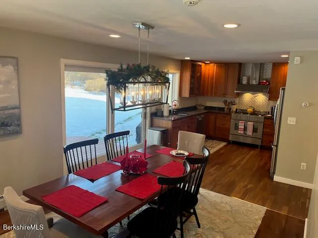 a kitchen with sink refrigerator dining table and chairs