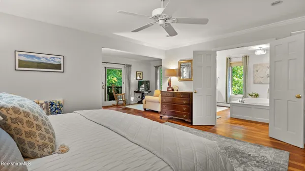 a bedroom with a large bed and a chandelier fan