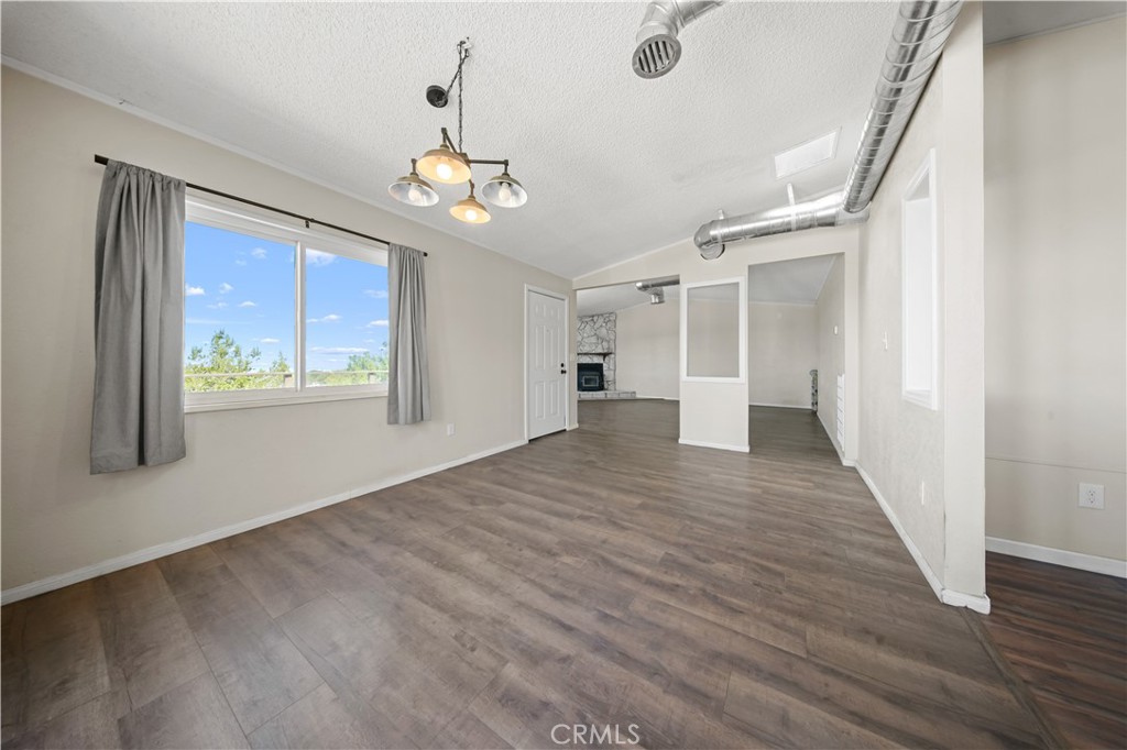 2033 Hollister Road Pinon Hills, CA 92372 - Photo 8 of 25 a view of an empty room with wooden floor and a window