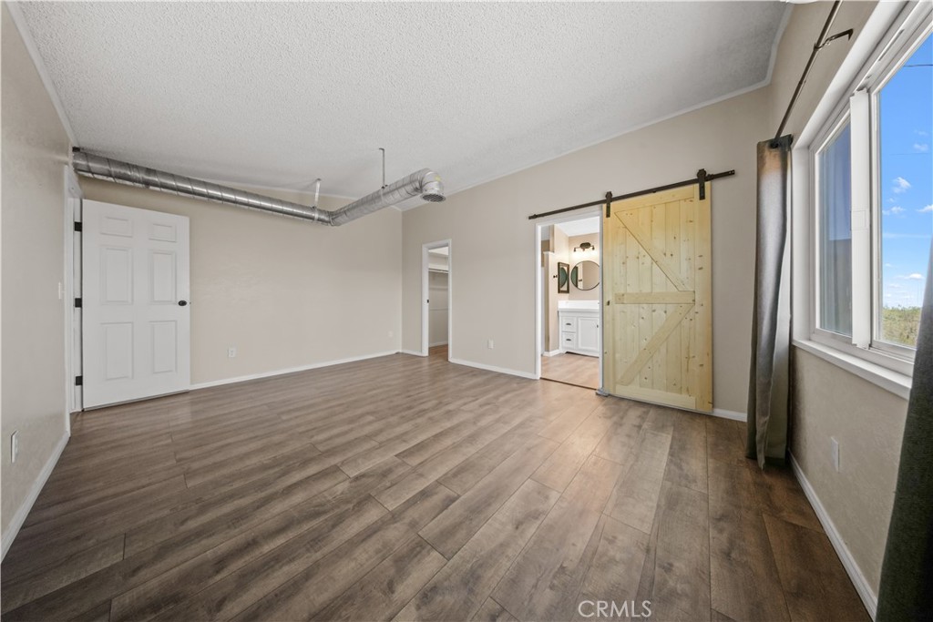 2033 Hollister Road Pinon Hills, CA 92372 - Photo 10 of 25 a view of an empty room with wooden floor and a window