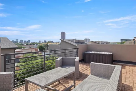 a view of a roof deck with couches and wooden floor