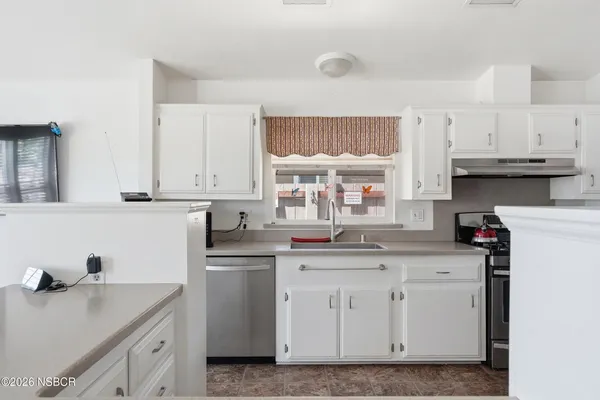 a kitchen with stainless steel appliances a refrigerator sink and cabinets