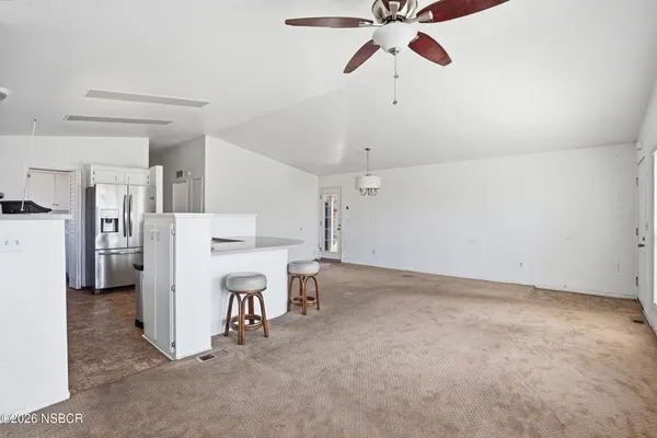 a view of a kitchen with refrigerator and a ceiling fan