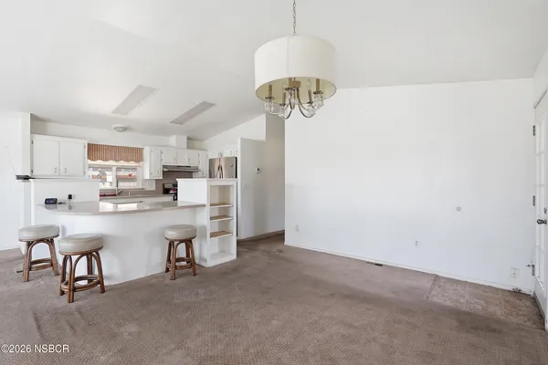 a kitchen with stainless steel appliances a table and chairs in it