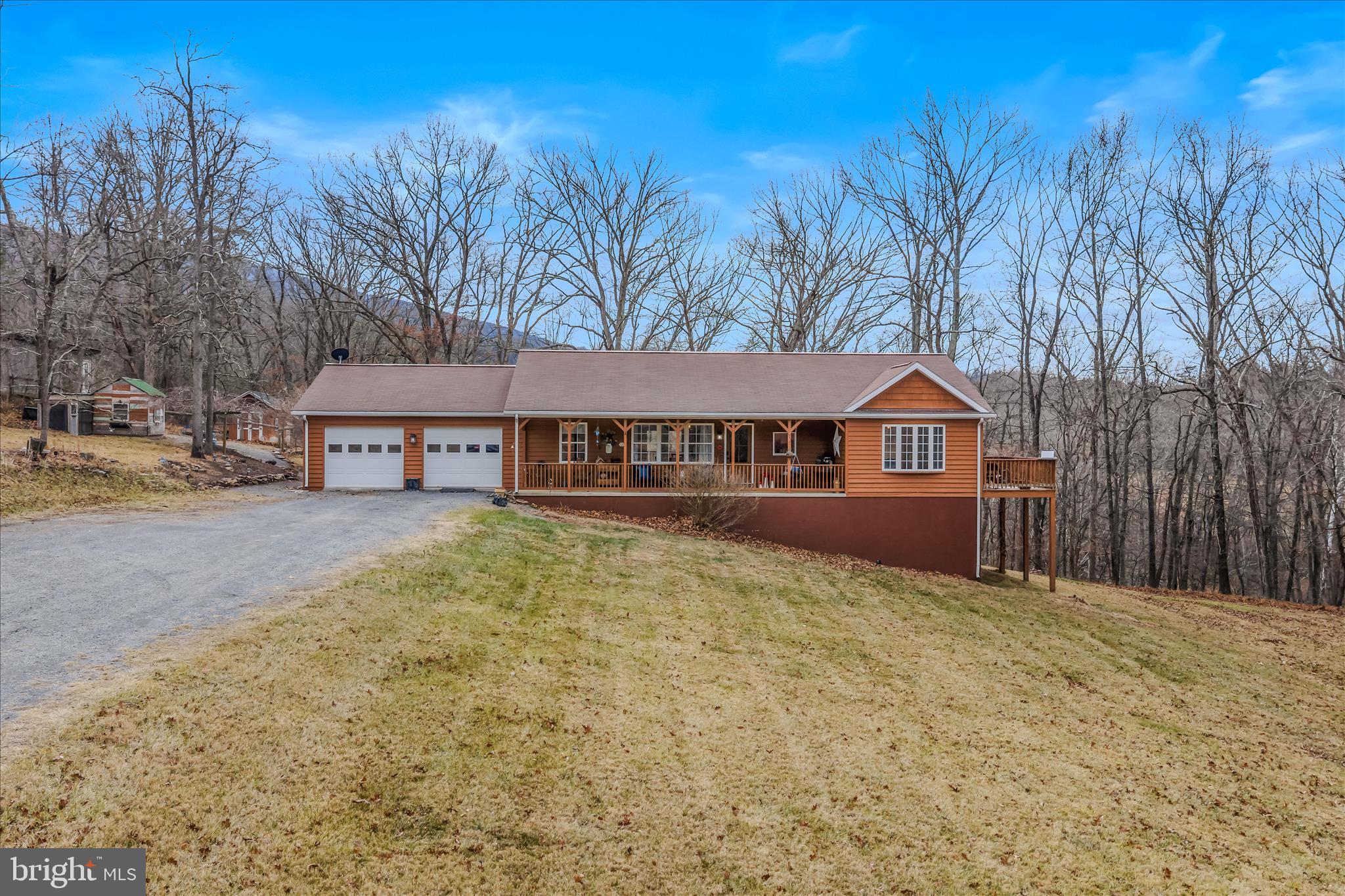 1636 Eckerd Lane Berkeley Springs, WV 25411 - Photo 3 of 85 a front view of a house with large trees and fence