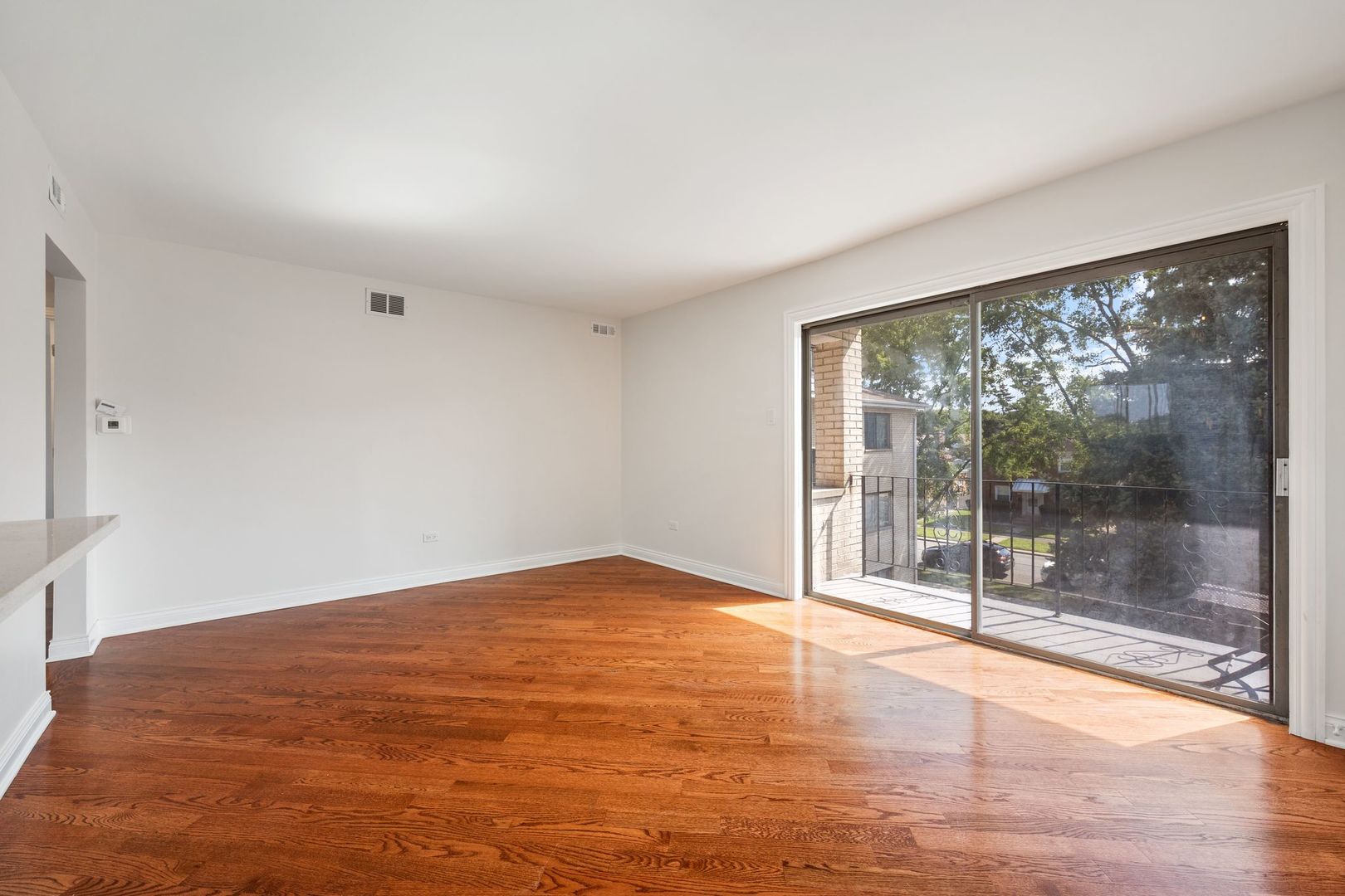 6332 Pershing Road, Unit 3C Berwyn, IL 60402 - Photo 3 of 16 a view of an empty room with wooden floor and a window