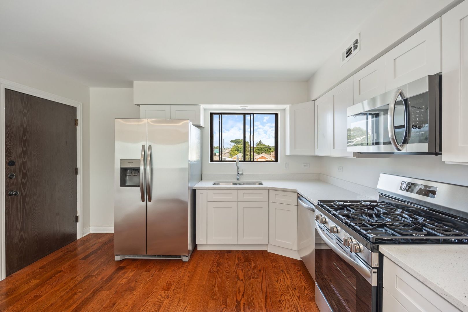 6332 Pershing Road, Unit 3C Berwyn, IL 60402 - Photo 7 of 16 a kitchen with stainless steel appliances a refrigerator sink and stove