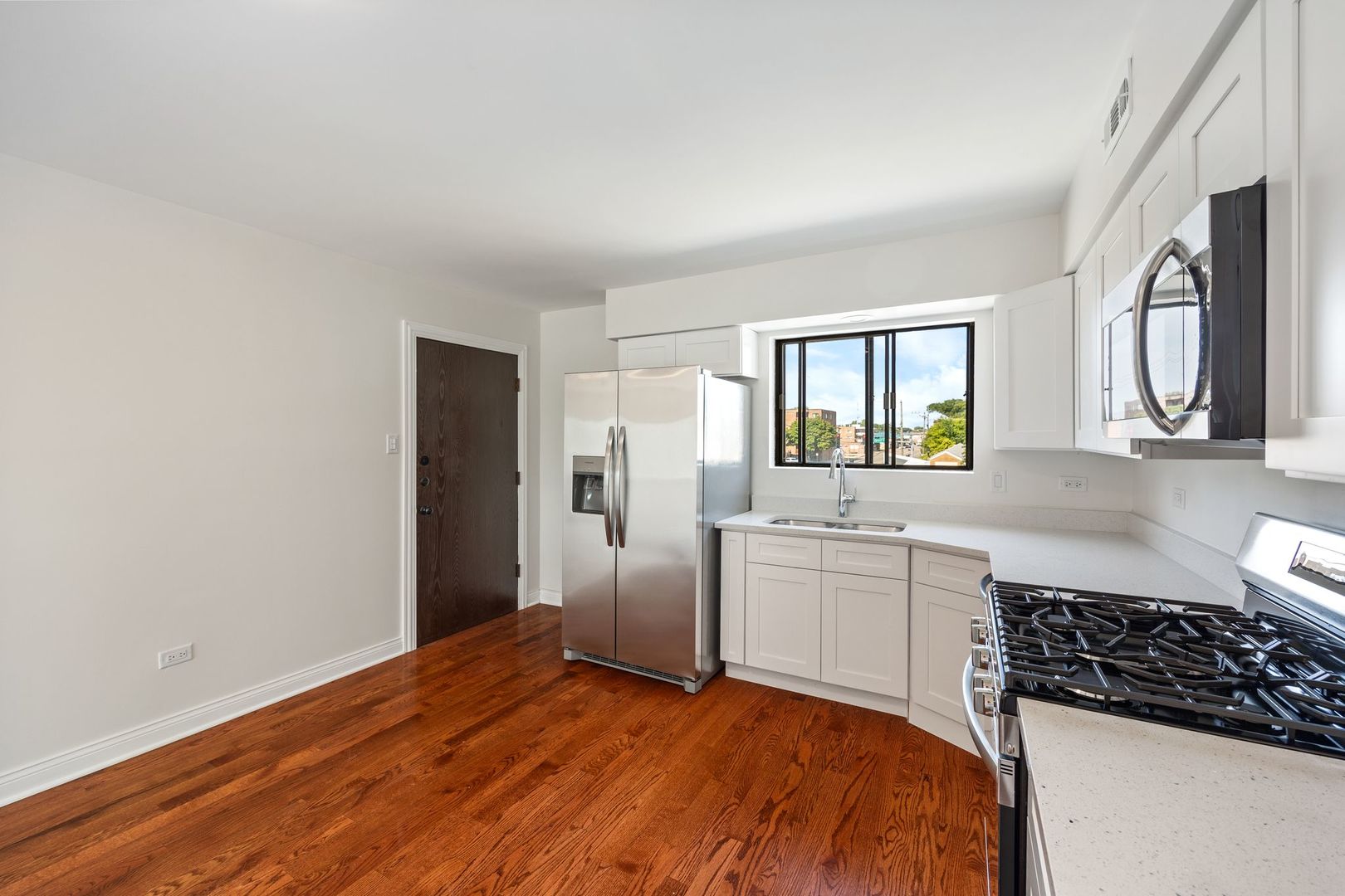 6332 Pershing Road, Unit 3C Berwyn, IL 60402 - Photo 8 of 16 a kitchen with stainless steel appliances granite countertop a stove a sink and a refrigerator