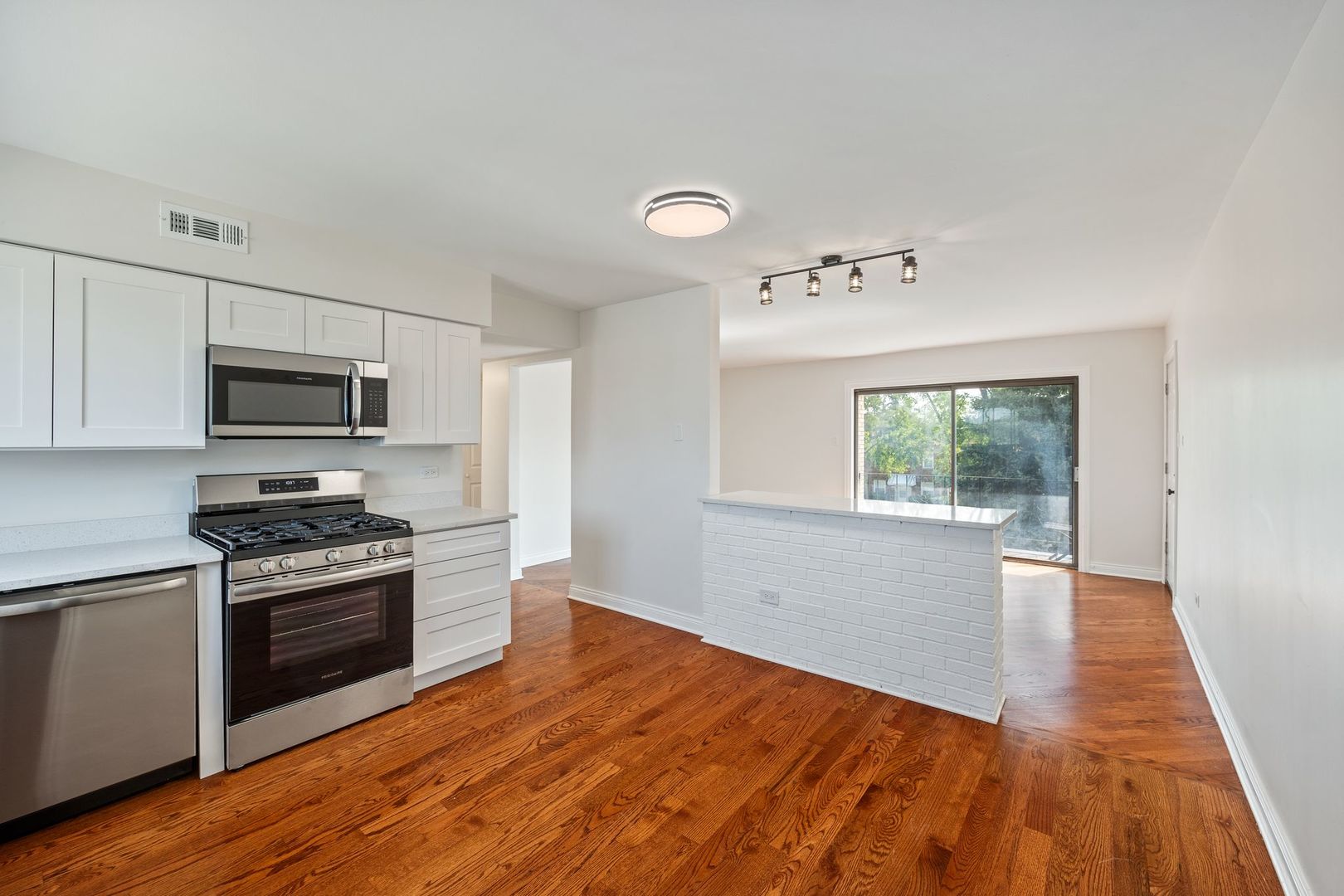 6332 Pershing Road, Unit 3C Berwyn, IL 60402 - Photo 9 of 16 a kitchen with a stove a sink and a microwave