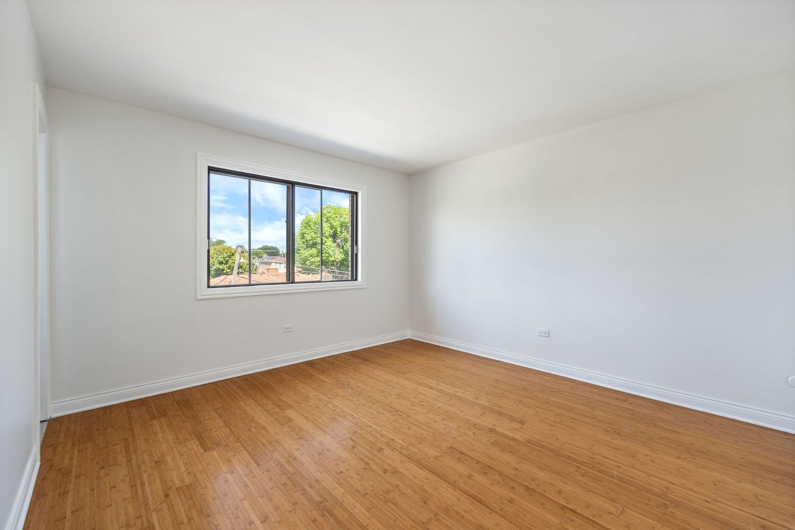 6332 Pershing Road, Unit 3C Berwyn, IL 60402 - Photo 10 of 16 an empty room with wooden floor and windows