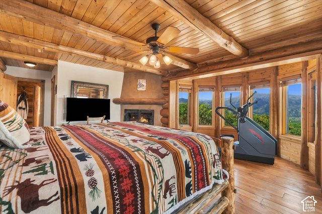 1701 Oak Road Coalville, UT 84017 - Photo 26 of 71 Wood-paneled ceilings with exposed log beams, built-in fireplace with a stucco surround, bay window with multiple individual panes, and wood-finish flooring