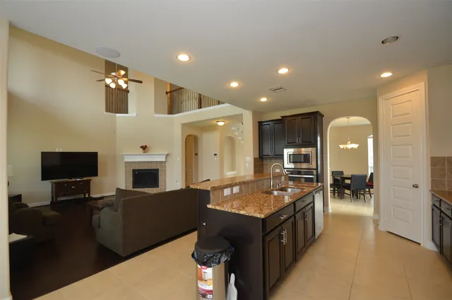 a spacious bathroom with a granite countertop sink a mirror and shower