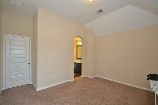 a bedroom with a bed and a lamp on the dresser