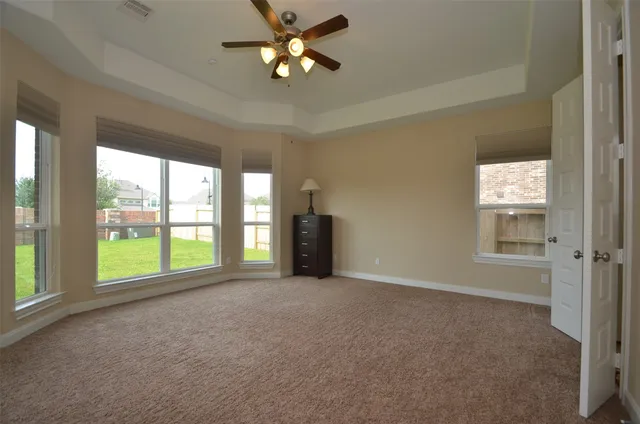 a view of a livingroom with a chandelier fan and windows