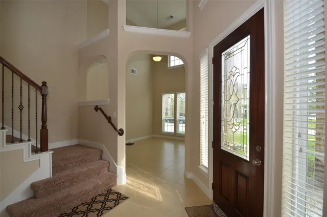 a view of a hallway with a glass door and furniture