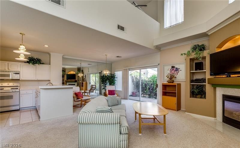 5272 Island Chain Road Las Vegas, NV 89118 - Photo 26 of 31 A spacious living room seamlessly connects to the kitchen, creating an open and inviting atmosphere.