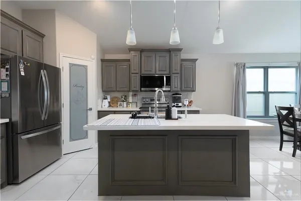 a kitchen with kitchen island a sink and a refrigerator