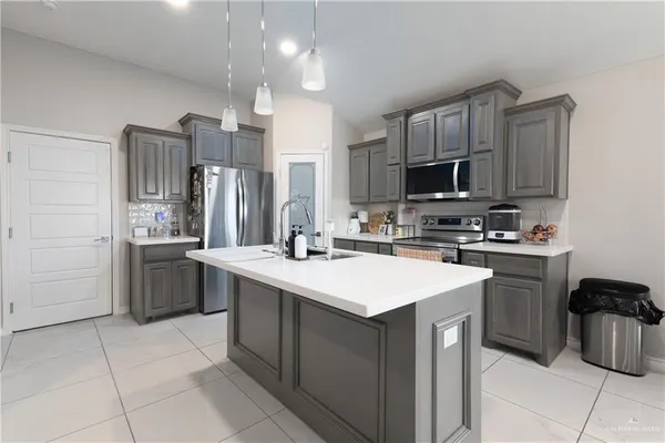 a kitchen with a sink a stove a refrigerator and cabinets