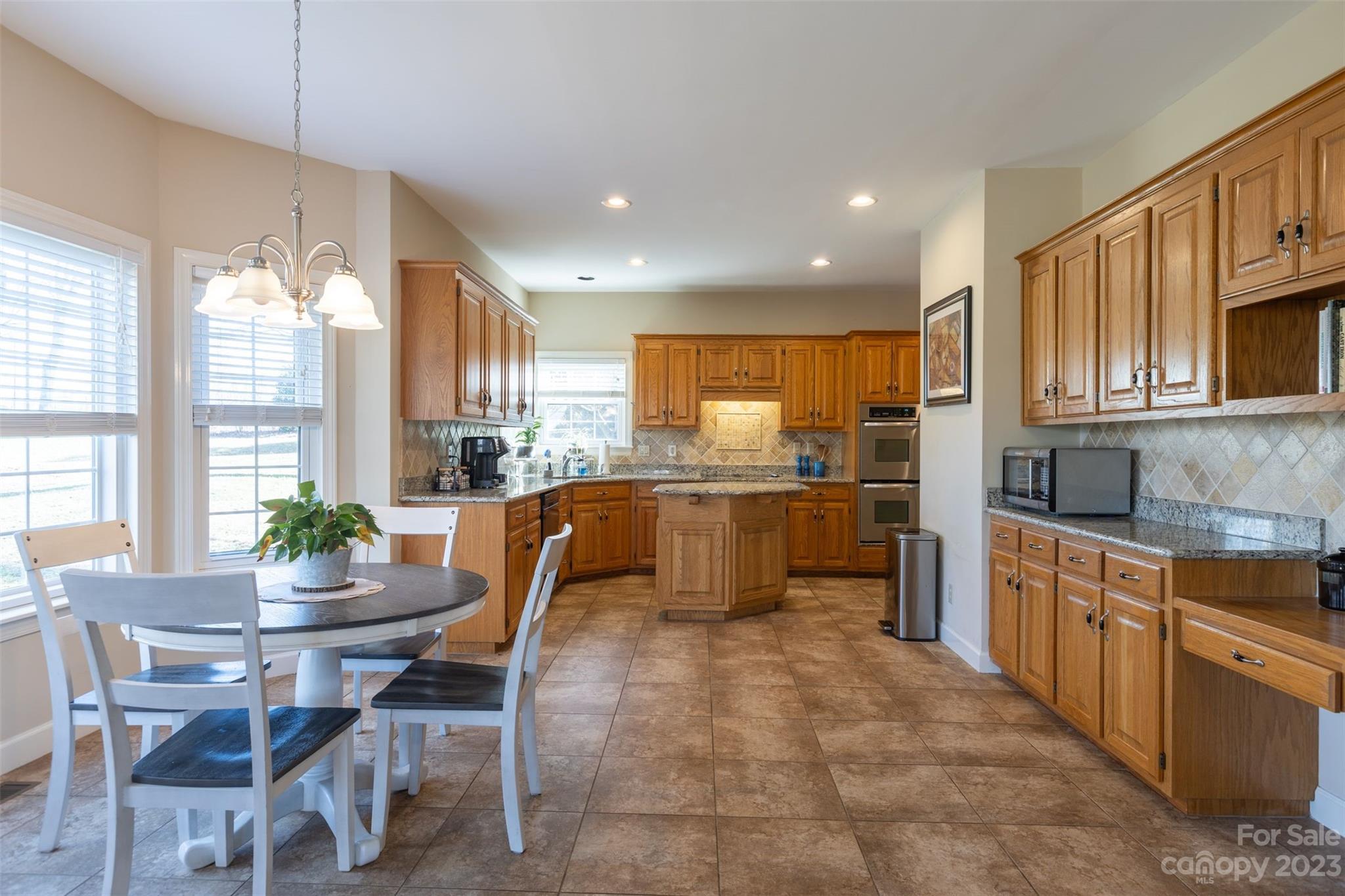 1378 Braeburn Road Northwest Concord, NC 28027 - Photo 18 of 36 a kitchen with kitchen island granite countertop wooden cabinets and counter space