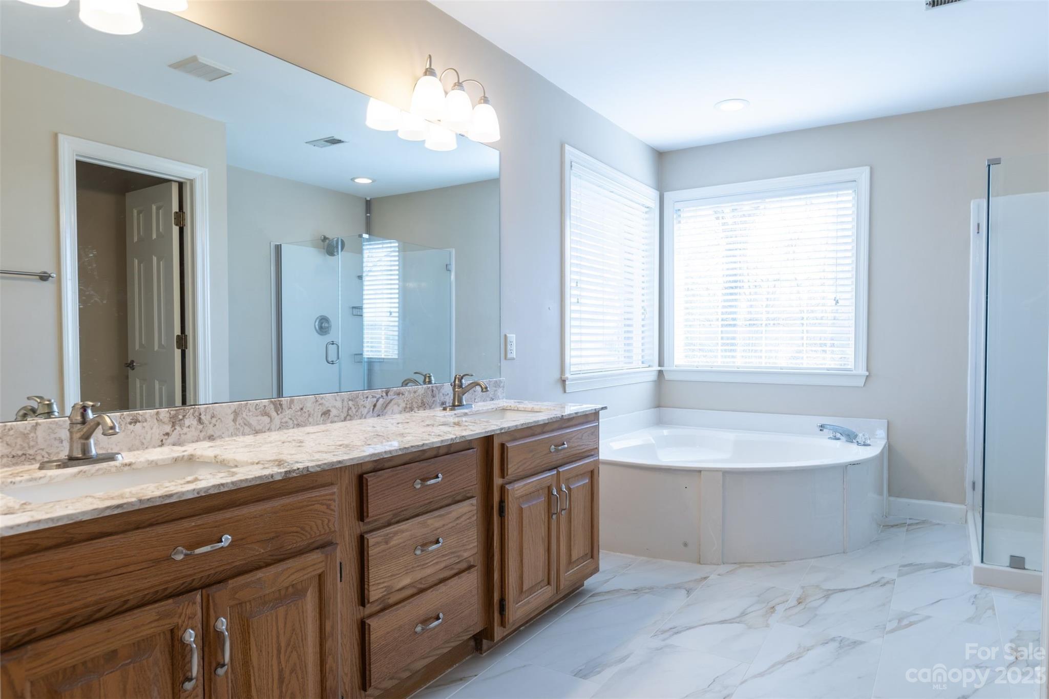 1378 Braeburn Road Northwest Concord, NC 28027 - Photo 25 of 36 a spacious bathroom with a double vanity sink large mirror and bathtub