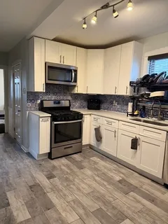 a kitchen with granite countertop white cabinets and white appliances