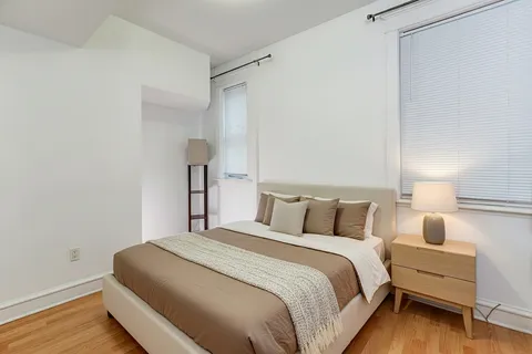 a bedroom with bed and wooden floor