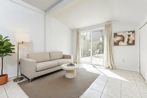 a living room with furniture and a floor to ceiling window