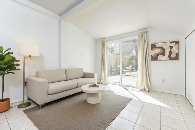 a living room with furniture and a floor to ceiling window