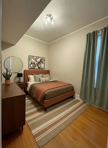 a bedroom with a bed and wooden floor