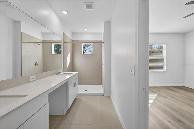 a bathroom with a granite countertop sink a mirror and a bathtub