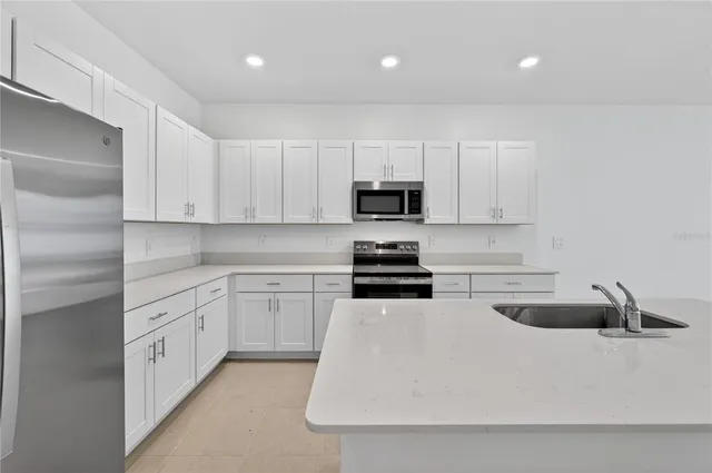 a kitchen with white cabinets and stainless steel appliances