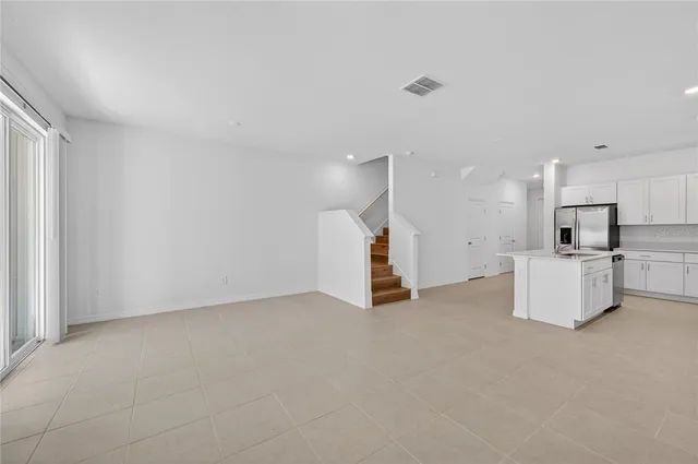 a view of kitchen with refrigerator sink and cabinets