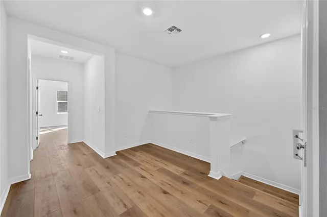 a view of empty room with wooden floor