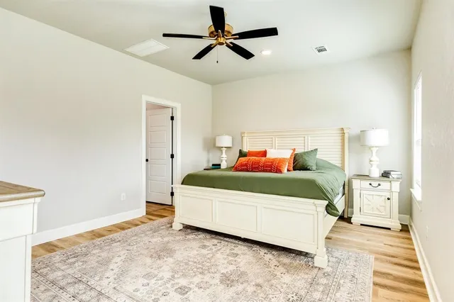 a bedroom with a bed and a chandelier fan