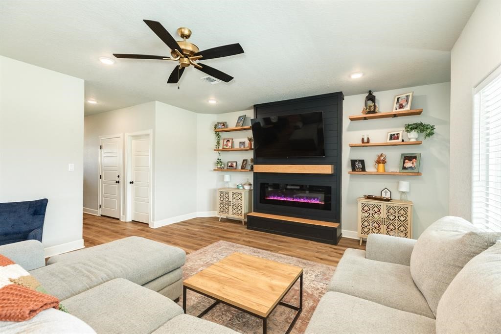 628 Greystone Lane Angleton, TX 77515 - Photo 6 of 33 a living room with furniture a flat screen tv and a fireplace