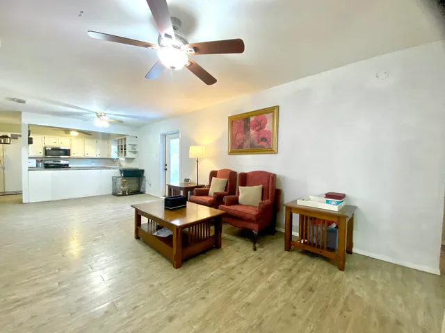 a living room with furniture and kitchen view