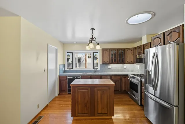 a kitchen with stainless steel appliances granite countertop a refrigerator and a stove