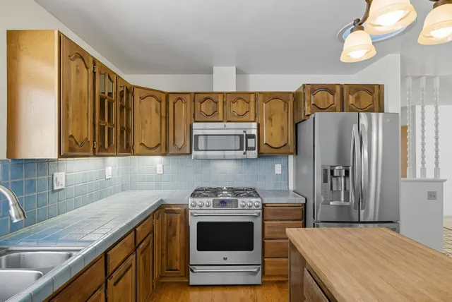 a kitchen with stainless steel appliances a stove cabinets and a refrigerator