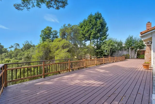 a view of a balcony with wooden floor and fence