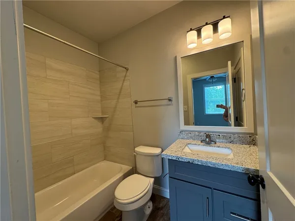 a bathroom with a granite countertop toilet a sink and a bathtub